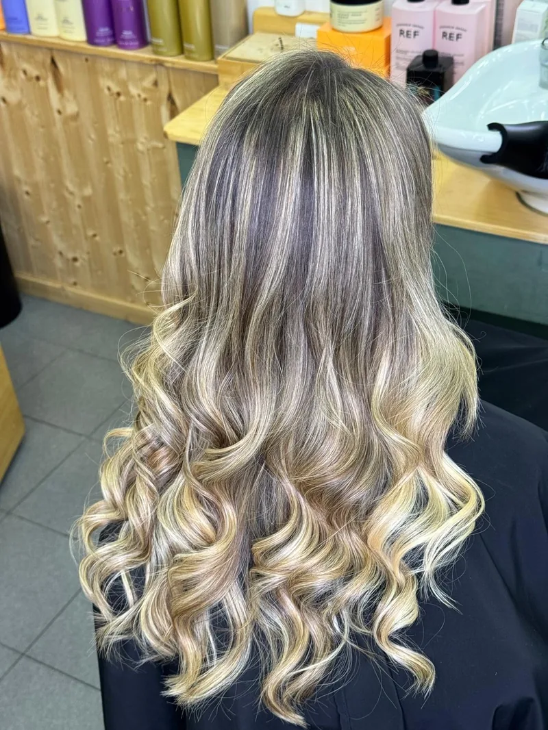 Balayage loiro em cabelo comprido ondulado, no salão