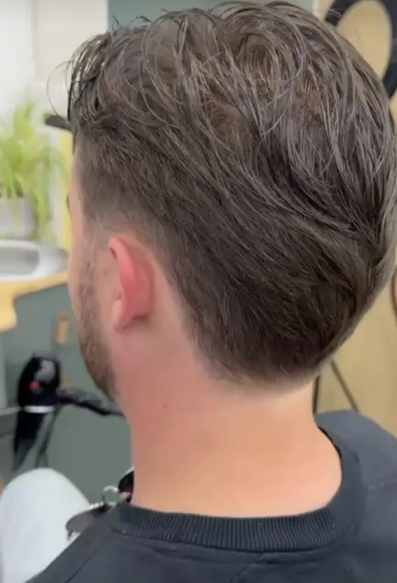 Corte de cabelo homem com nuca raspada e volume no topo, vista lateral